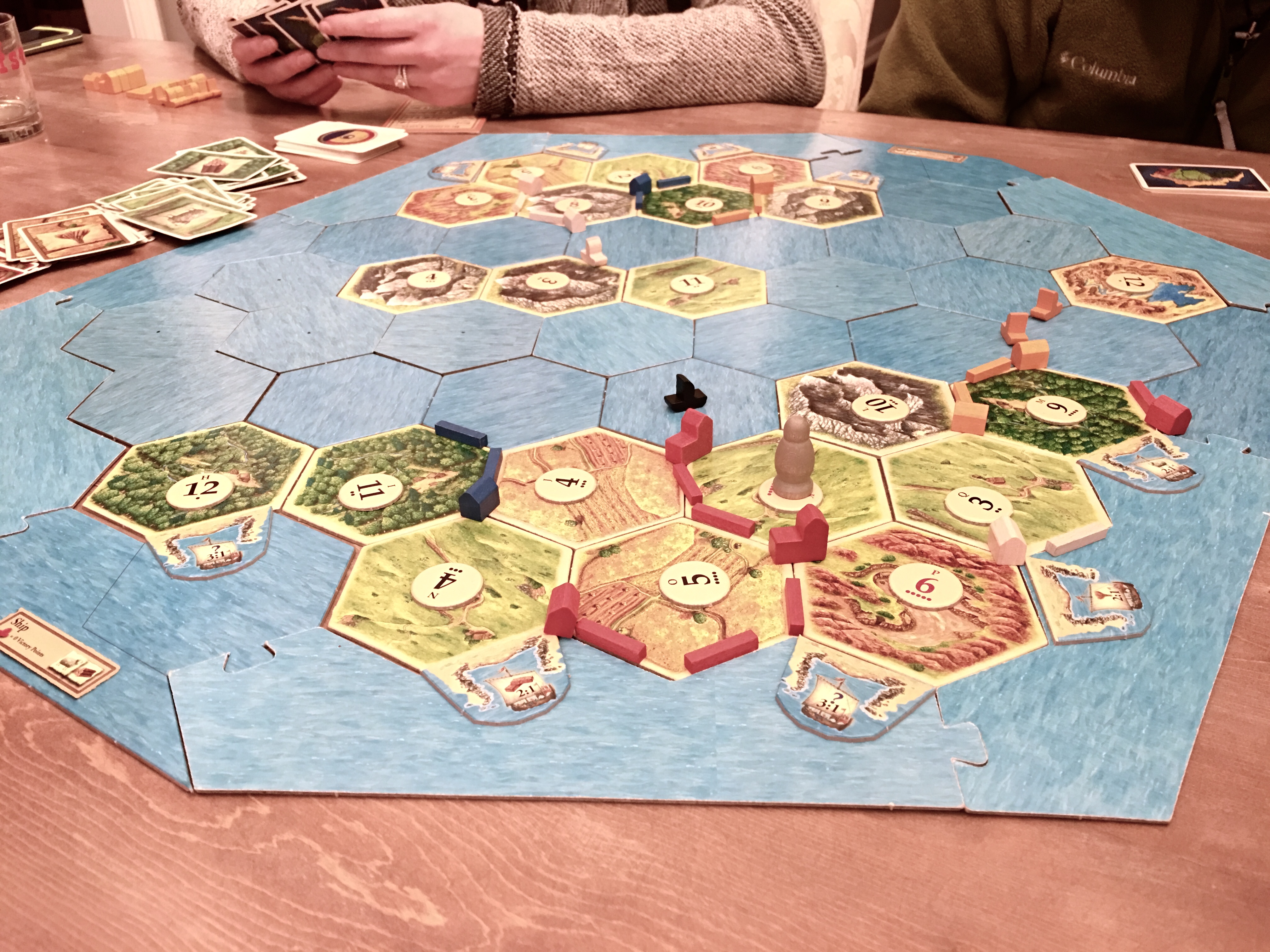 close up photo of playing settlers of catan on farmhouse table